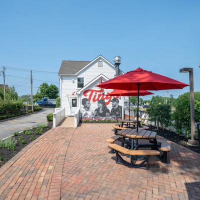 Outdoor patio seating with red umbrellas and a distinctive exterior mural.