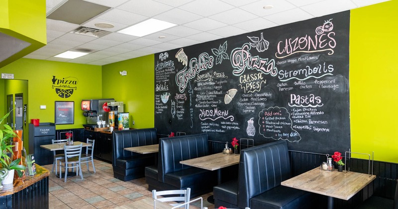 Interior, dining area, seating booths with tables, over-the-wall menu blackboard
