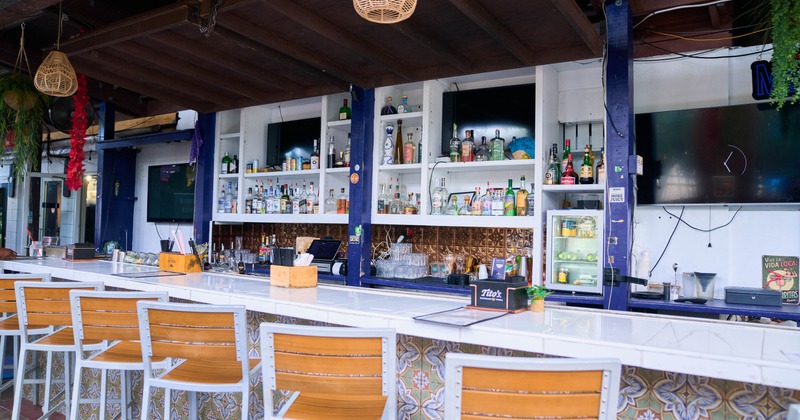 Open air bar with wooden stools and hanging lights