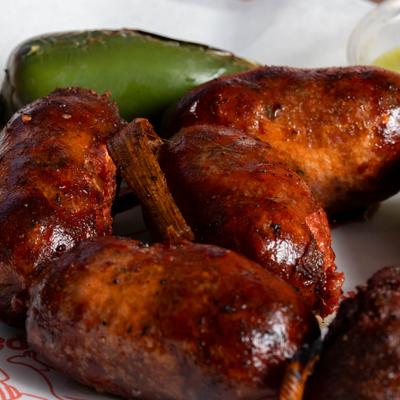 Salvadorian Sausage served with grilled jalapeno and a dipping sauce, closeup.