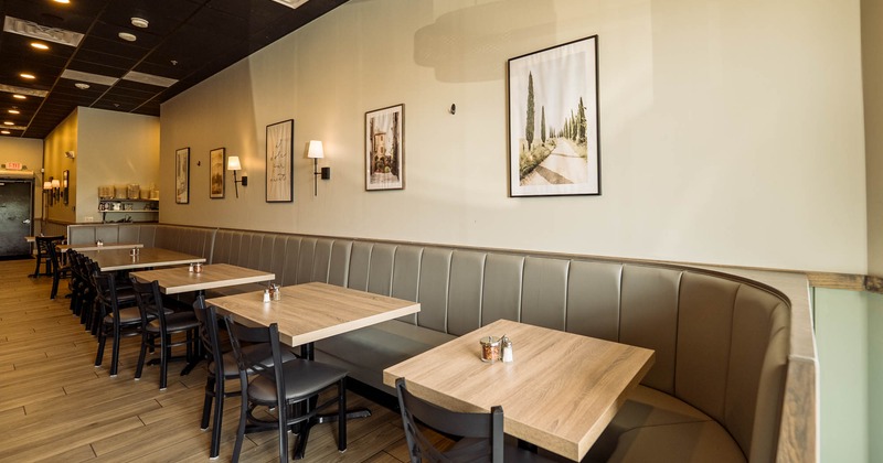 Interior, banquette seating, tables and chairs, framed pictures on the wall