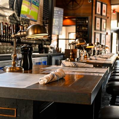 bar with stools, napkins, and brass lamps.