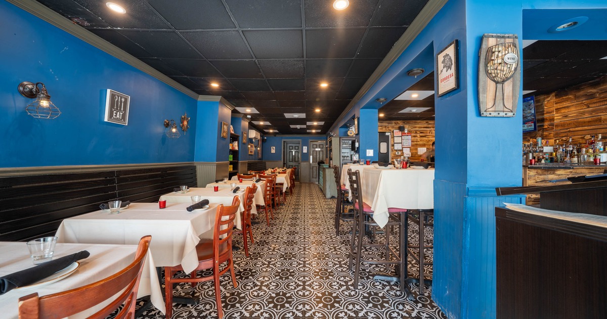 Interior - blue walls, white tablecloths, and black and white patterned flooring.