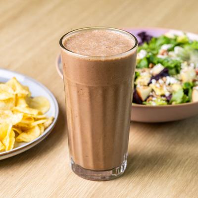 Chunky Monkey Smoothie served on the table with food in the background.