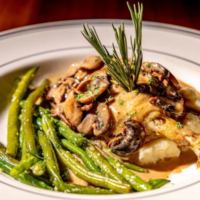 Duck leg with green beans and mushrooms.