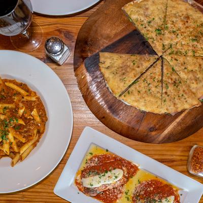 Focaccia with robiola cheese, eggplant rollatini. penne alla vodka, overhead view