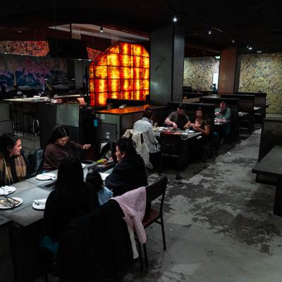 Dining room with booth seating and a decorative, warm-toned glowing wall.