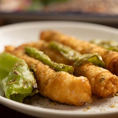 Phyllo Rolls garnished with crushed pistachios and green peppers.