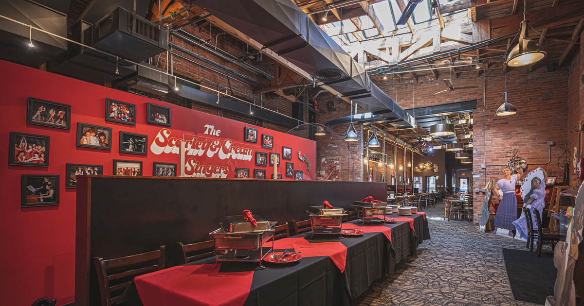 Interior, room with a long buffet table, red wall decorated with framed photos