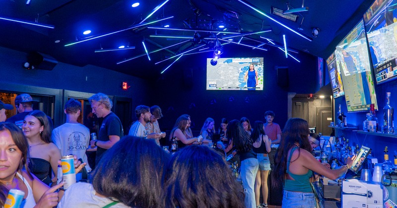 Interior, night party, screens, lights, people