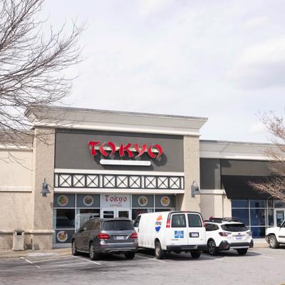 Restaurant exterior with signage and parked cars.