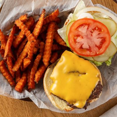 Cheeseburger with lettuce, onion, pickle, tomato and side of sweet potato fries.