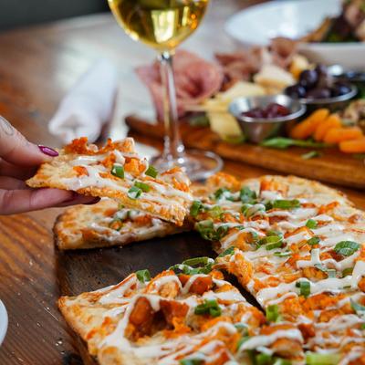 Hand holds piece of pizza