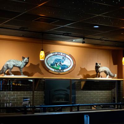 Interior of Silver Fox Lounge featuring two taxidermy foxes and a restaurant sign.