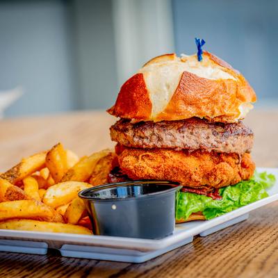 Mac Burger served with fries and a sauce for dipping.