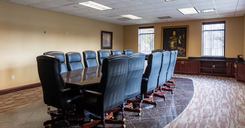 Interior, conference room, long wooden top table with fourteen comfy chairs on wheels