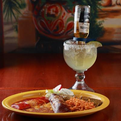 Three enchiladas on a plate with Coronarita Margarita