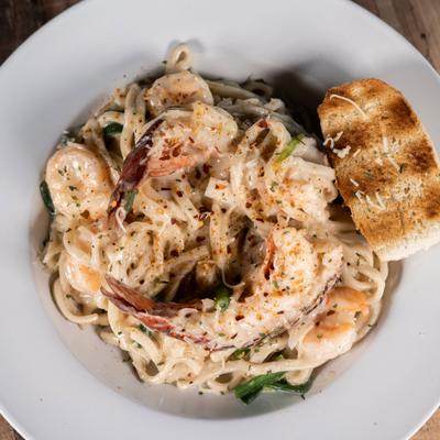 Lobster and shrimp Alfredo pasta with toasted bread on the side.