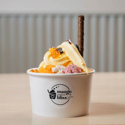Pinneapple frozen yogurt topped with orange boba pearls and wafer stick.
