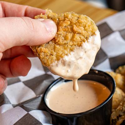 Fried pickle dipped in sauce.
