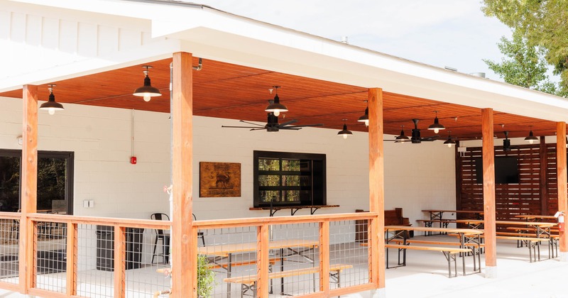 Covered outdoor patio with wooden beams and picnic tables