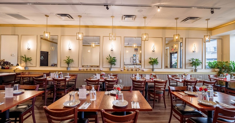 Interior of spacious and cozy dining area with set tables