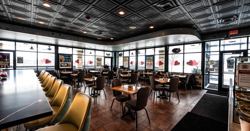 Interior, dining area, restaurant entrance, wooden top tables with chairs, tile flooring