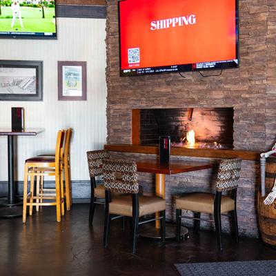 Seating and tables near wall fireplace.