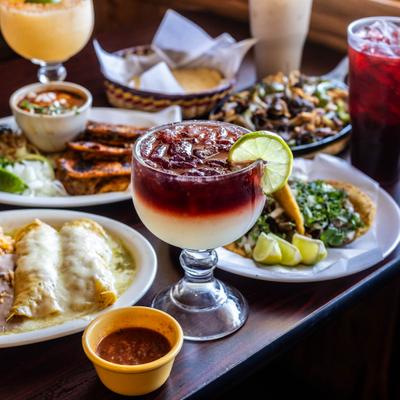 Glass of Sangria served on the table alongside other drinks and food.