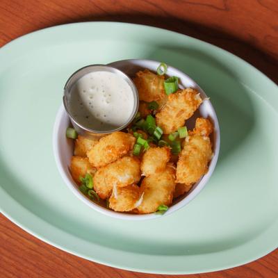 Fried cheese curds with a white sauce, top view.