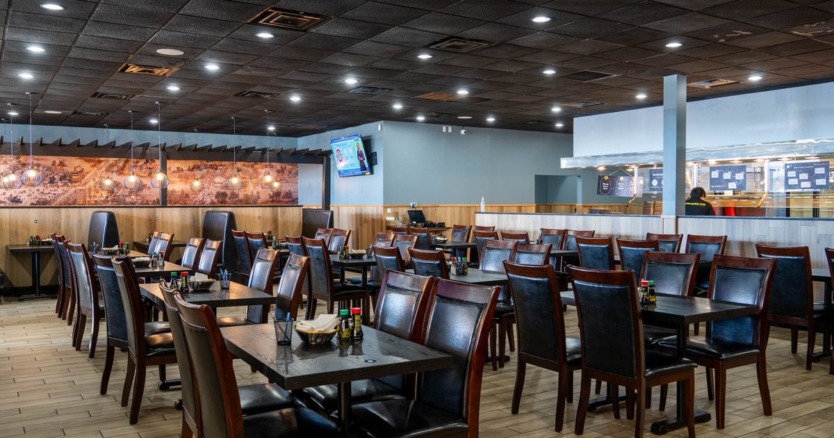 Interior, dining area, tables with chairs, serving station and kitchen in the back