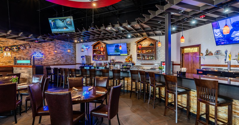 Cozy and spacious interior dining area and long bar counter with wooden stools
