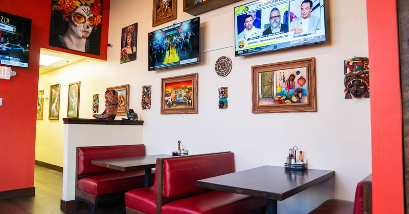 Dining area, red vinyl booths, framed pictures and TV screens