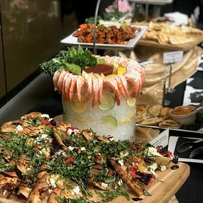 A buffet table featuring shrimp, assorted vegetables, and best food in Bellevue ready for guests to serve..