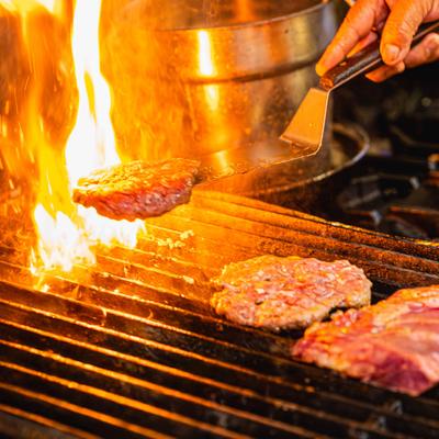 Kitchen action shots, Chef cooking meat on a grill.