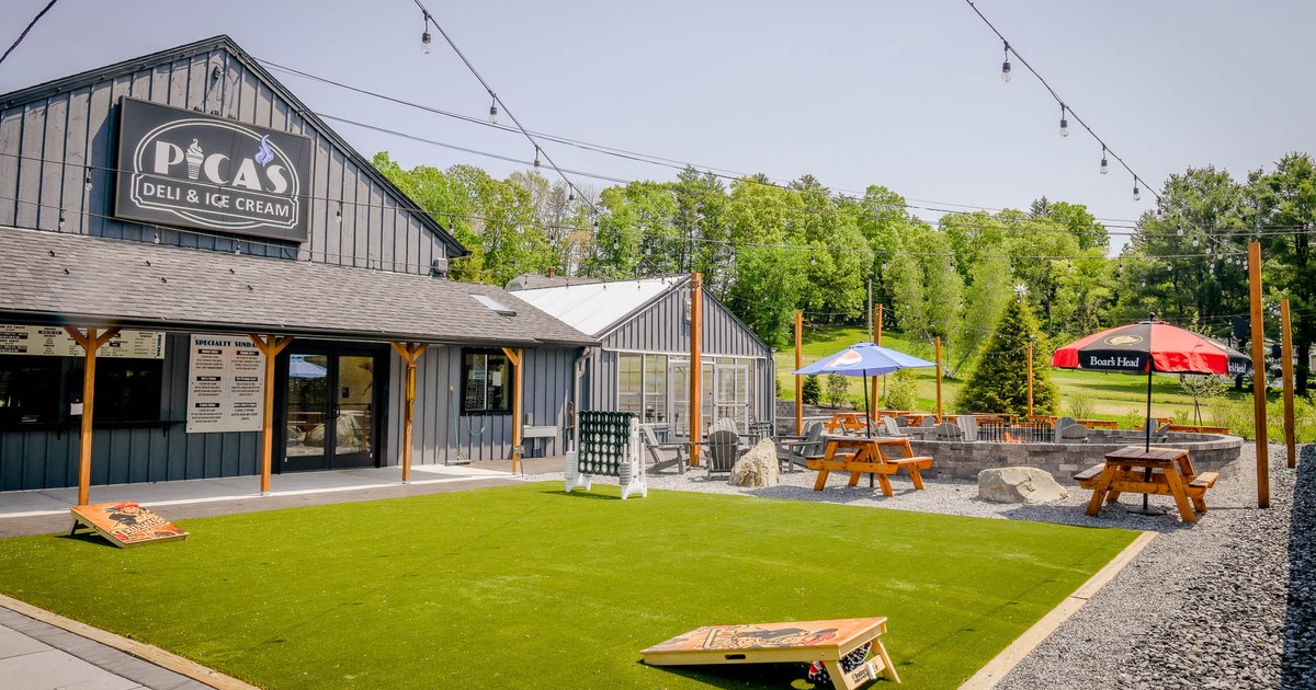 Outdoor space with grass area and tables nearby