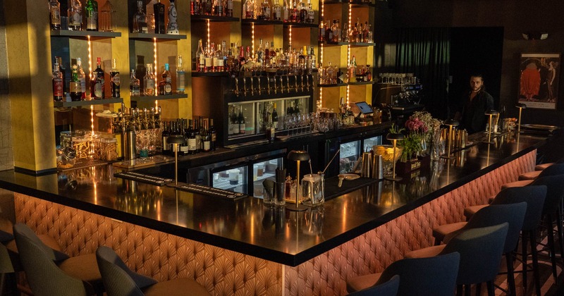 Interior, bar area, marble top bar with comfy stools, tall drink shelves in the back