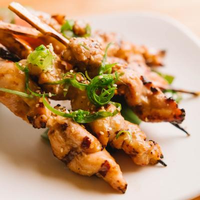 Grilled chicken skewers with green garnish.