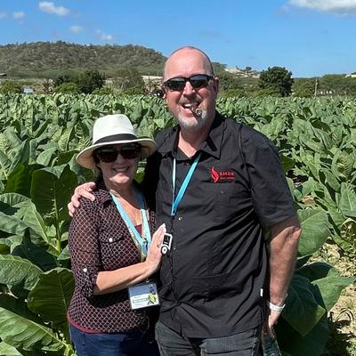 The owner and his spouse posing for the shot on a tobacco field.