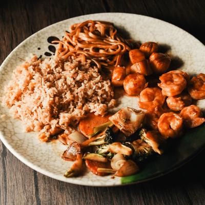 Shrimp and scallops hibachi meal with vegetables, rice, and noodles.