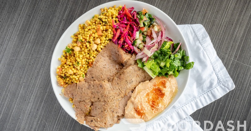 Gyro with hummus, shredded lettuce, red cabbage, cucumber, red onion and couscous