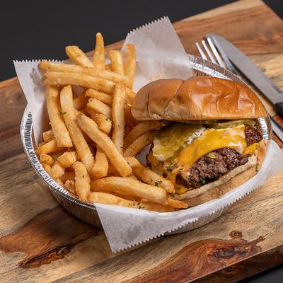 Smash burger served with fries and a dip.