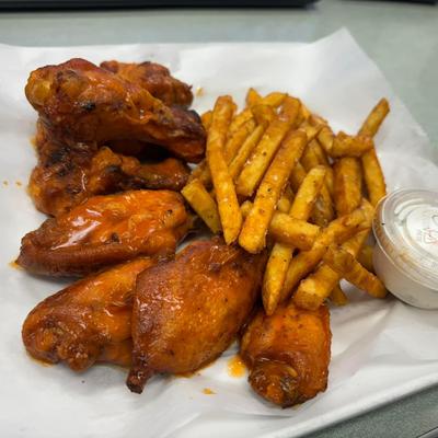 Chicken wings served with fries and ranch sauce.