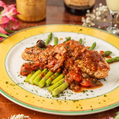 Salmon sauteed with cherry tomatoes, olives, capers, and served with asparagus.