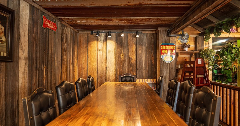 A vast wooden table and upholstered chairs close up