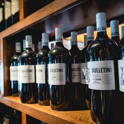 Red wine bottles on shelves.
