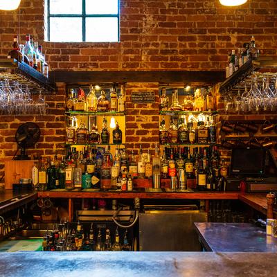 Interior, a view behind the counter, bottles on shelves, clean glasses stacked