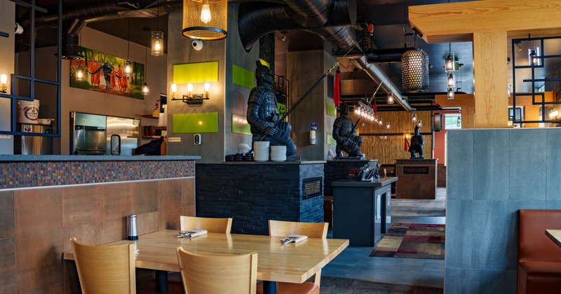 Interior view of a modern restaurant featuring wooden tables, green wall panels