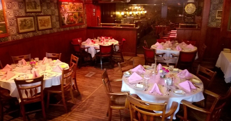 A restaurant interior featuring elegantly set tables and chairs