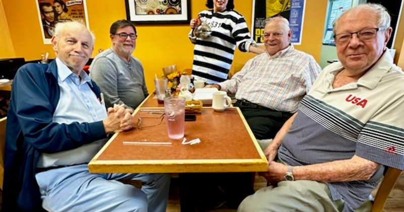 Four people seated at a restaurant table